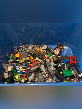 Big Tub full of Legos with a bag full of  Different Guide Books!